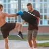 Rúgópajzs Muay Thai és kick-box edzőpárna, 8 cm vastag ütéscsillapító réteggel 38x20x18 cm, fekete/piros/fehér