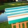 Children's wooden frame sandbox with veranda with protective roof and sunshade in green color