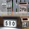 Solar lamp illuminating house number in small size. Outdoor design, flat shape, stainless steel, 2 LED lights. Waterproof and bird-proof design